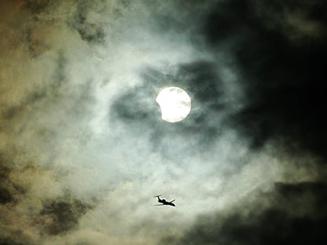 APOD: Clouds, Plane, Sun, Eclipse - April 11, 2005