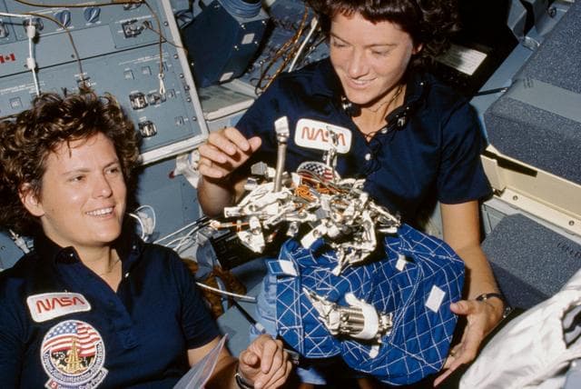 NASA image: Astronauts Sullivan and Ride show sleep restraint equipment