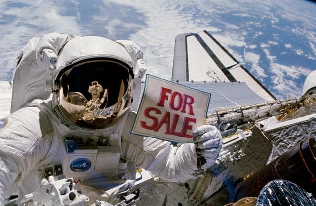 NASA image: Astronaut Dale Gardner holds up for sale sign after EVA