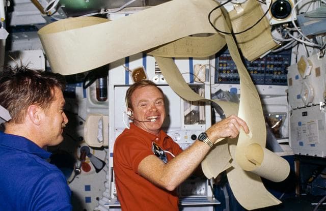 NASA image: Astronauts Bridges and England surrounded by teleprinted messages