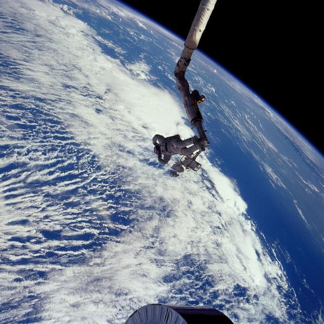 NASA image: Astronaut James van Hoften on RMS tracking Syncom IV-3 after deployment