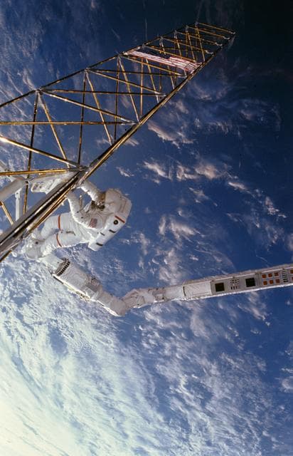 NASA image: Astronaut Jerry Ross on RMS holds on to ACCESS device