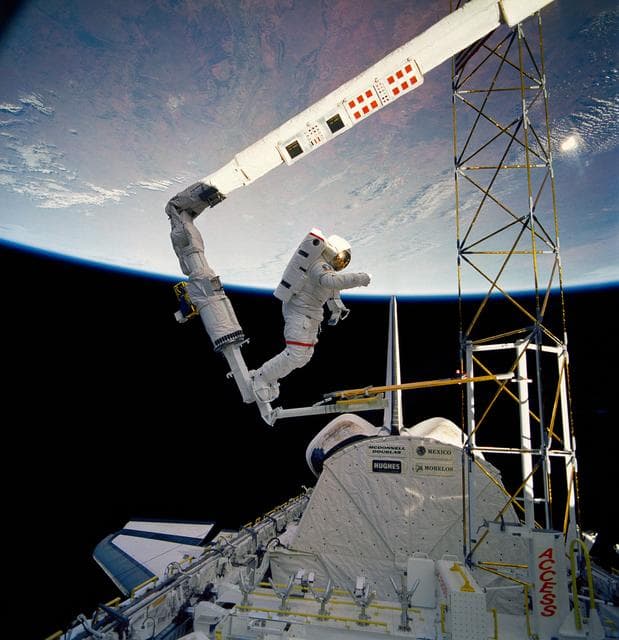 NASA image: Astronaut Jerry Ross on RMS holds on to ACCESS device