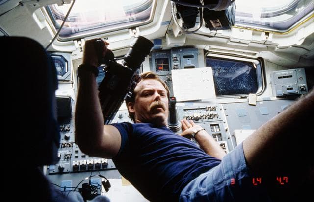 NASA image: Astronaut Robert Gibson prepares to use motion picture camera