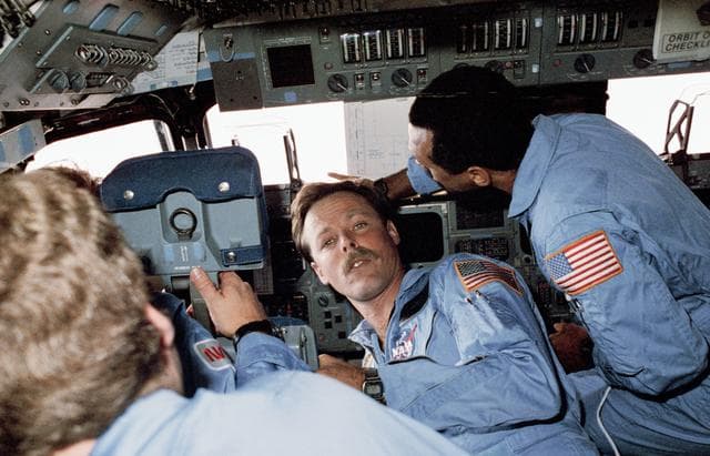 NASA image: Four STS 61-C crewmembers gather at the commander's station