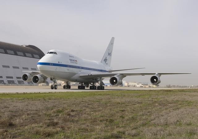 NASA image: NASA's SOFIA airborne observatory taxis past Hangar 1, the 1930s-era dirigible hangar at Moffett Field, during its first visit to NASA Ames Research Center