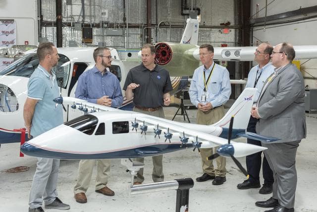 NASA image: Armstrong X-57 team brief NASA Administrator Bridenstine about the progress of making a combustion aircraft into an all-electric airplane. X-57 is in Scaled Composites hangar at Mojave Air & Space Port in California. Model of the final aircraft design sta