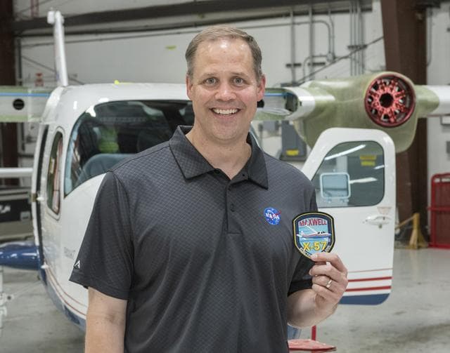 NASA image: NASA Administrator Bridenstine receives X-57 all-electric aircraft program patch standing in front of the X-57 being modified at Scaled Composites at Mojave Air and Space Port in California.