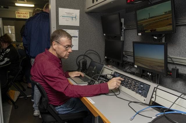 NASA image: NASA researcher Dennis Iannicca adjusts a control board in the Mobile Operations Facility to gather Automatic Dependent Surveillance-Broadcast signal data at NASA’s Armstrong Flight Research Center in Edwards, California on Sept. 23, 2024.