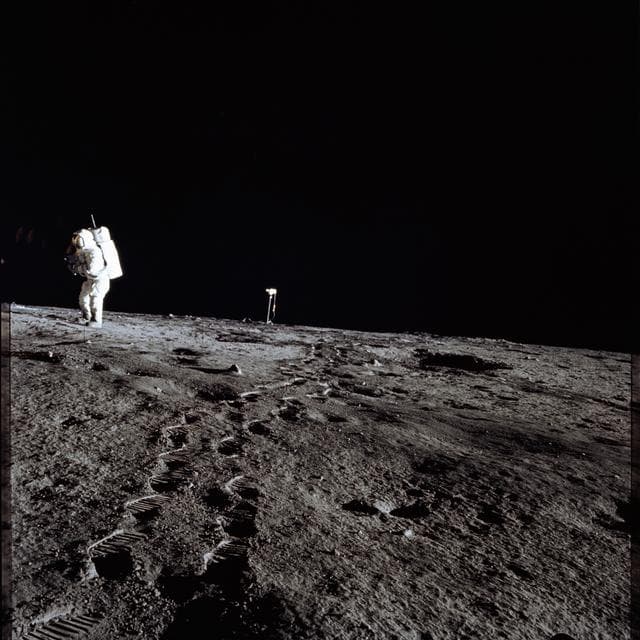 NASA image:    Apollo 12 Mission image - Photo of Al Bean and the TV taken from just inside the rim of Surveyor Crater 