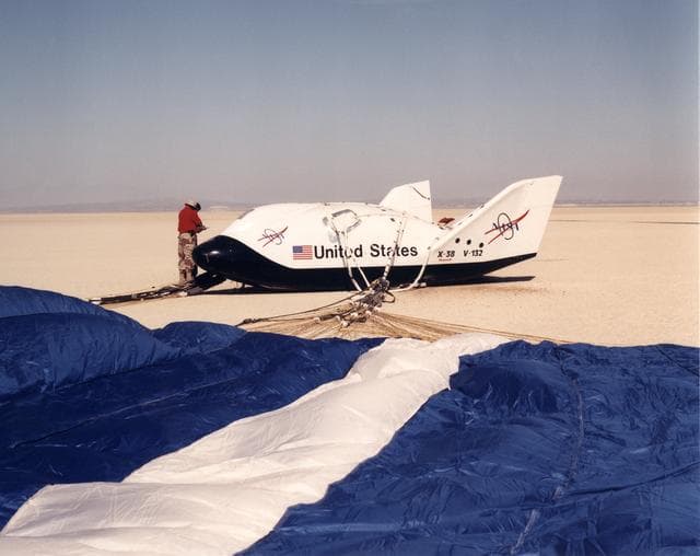 NASA image: A Ground Crewman Checks Over the X-38 Second Prototype Following the Lakebed Landing of Its Fifth Flight at Edwards Air Force Base