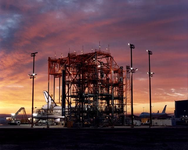 NASA image: STS-92 - Orbiter in Mate-Demate Device (MDD) at sunrise with Shuttle Carrier Aircraft (SCA) in background