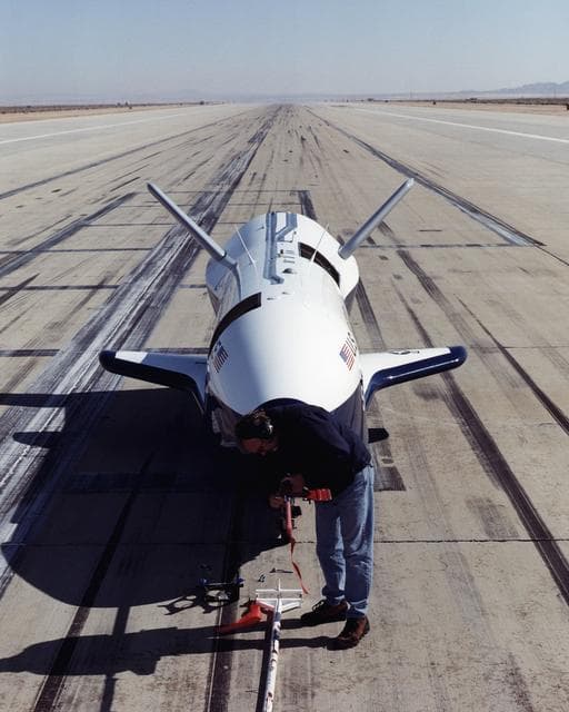 NASA image: A worker attaches covers for the nose pitot boom before removing the unpiloted X-40 from the runway at Edwards Air Force Base, California, following its successful free-flight on March 14, 2001