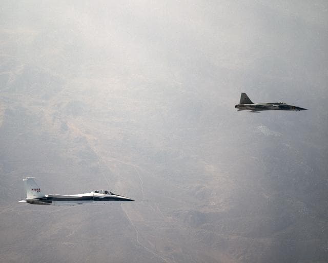 NASA image: NASA's F-15B Research Testbed aircraft flies in the supersonic shock wave of a U.S. Navy F-5E as part of the F-5 Shaped Sonic Boom Demonstration (SSBD) project.