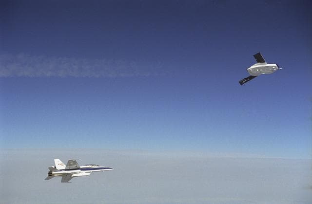 NASA image: X-45A in flight with F-18 #846 chase aircraft, during first GPS-guided weapon demonstration flight