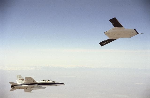 NASA image: X-45A in flight with F-18 #846 chase aircraft, during first GPS-guided weapon demonstration flight