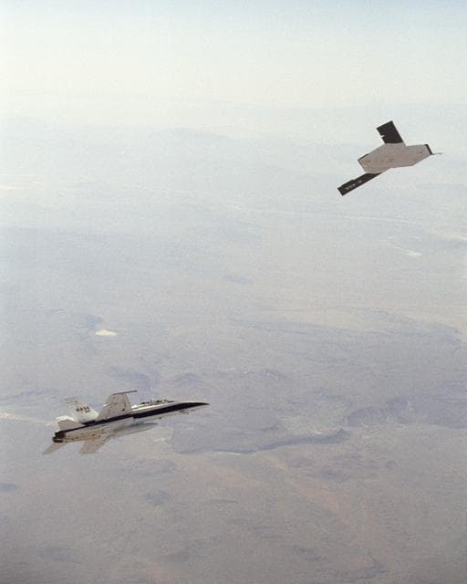 NASA image: X-45A in flight with F-18 #846 chase aircraft, during first GPS-guided weapon demonstration flight