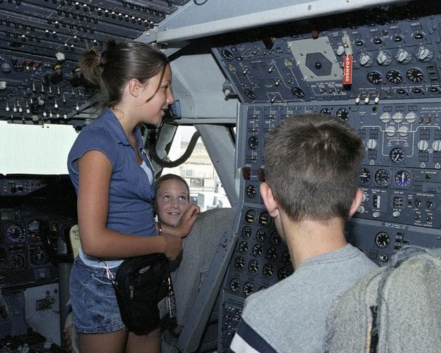 NASA image: Leah Robson, Bridgette Puljiz and Zachary Johnson(back to camera) in the flight deck of NASA's 747 shuttle carrier during Take Your Children to Work Day