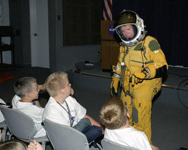 NASA image: Dryden historian Christian Gelzer explains functions of a high-altitude pressure suit to (left to right) Brandon Blankenship, Garrett Clay and Eddie Patterson