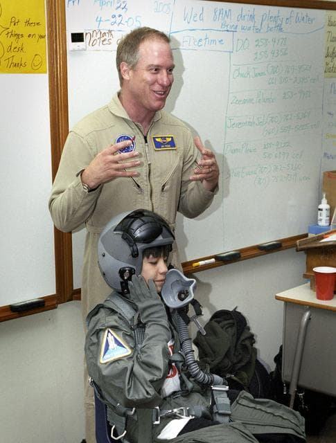 NASA image: While NASA Dryden's Jim Ross outlined his job as an aerial photographer, student Leo Banuelos learned first-hand about the gear Ross wears in the cockpit.