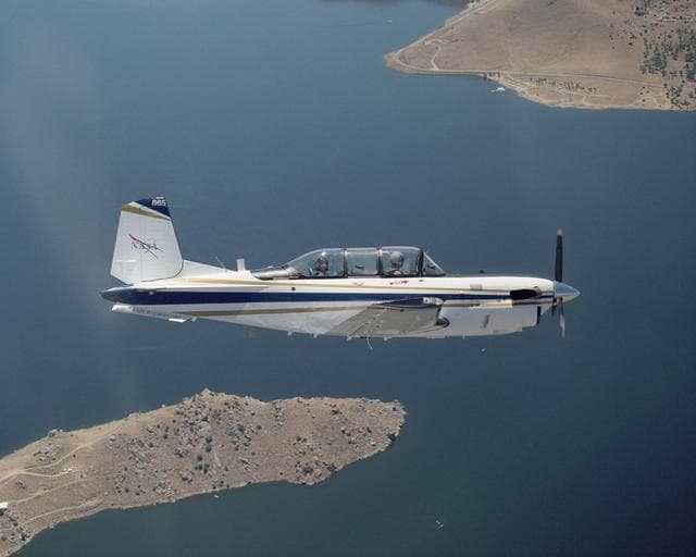 NASA image: A Beech T-34C aircraft used by NASA Dryden Flight Research Center for mission support banks over Lake Isabella in Kern County during a recent flight