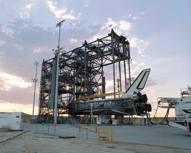NASA image: The sun sets on the Space Shuttle Discovery during post-flight processing in the Mate-Demate Device (MDD), following its landing at NASA DFRC in California