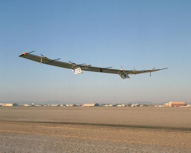 NASA image: With turbulence-measurement booms projecting ahead of the wing, Pathfinder-Plus soars aloft over Rogers Dry Lake on its final research flight from NASA Dryden.