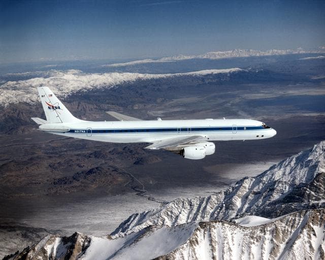 NASA image: DC-8 Airborne Laboratory in flight over snow-capped Sierra Nevada mountain range