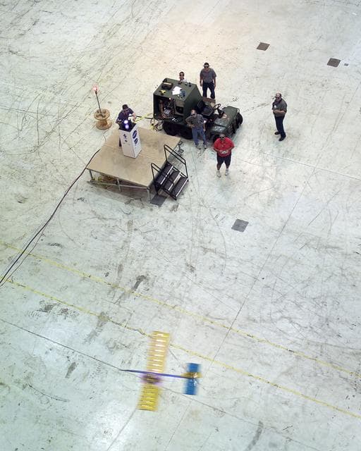 NASA image: Powered by a laser beam directed at it from a pedestal, a model plane makes the first flight of an aircraft powered by laser energy inside a building at NASA Marshall.