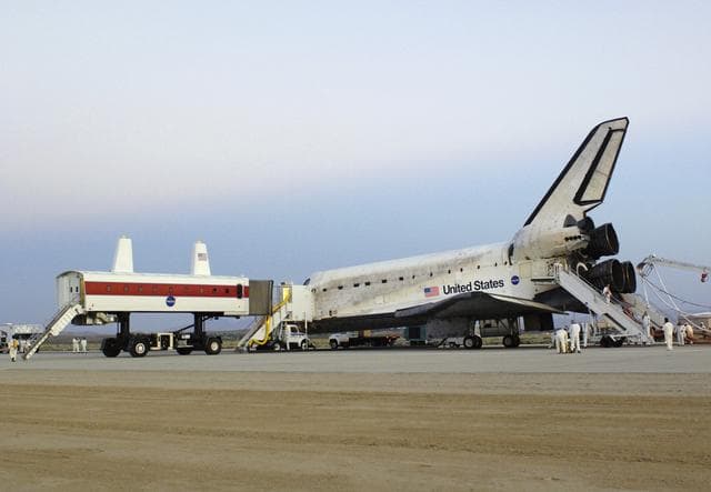 NASA image: NASA's Crew Transport Vehicle, or CTV, pulls up to the Space Shuttle Discovery to offload the crew after a successful landing August 9, 2005