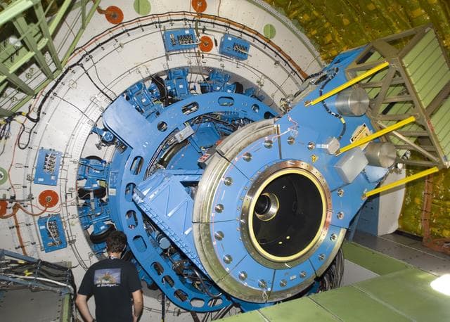 NASA image: A technician examines the instrument mounting structure and bulkhead of the German-built infrared telescope installed in NASA's SOFIA airborne observatory