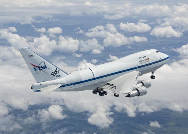 NASA image: NASA's Boeing 747SP SOFIA airborne observatory soars over a bed of puffy clouds during its second checkout flight over the Texas countryside on May 10, 2007