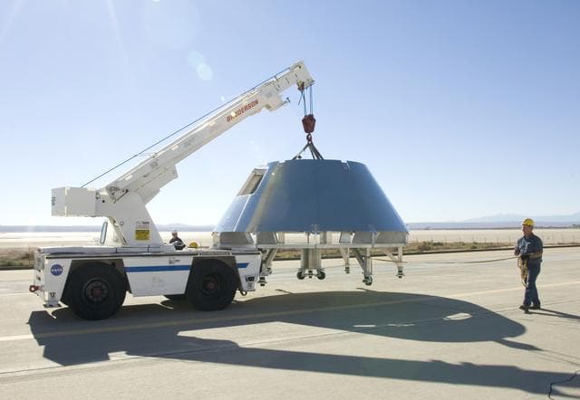 NASA image: Rogers Dry Lake served as a backdrop for a mockup Orion crew module built by NASA Dryden's Fabrication Branch as it was relocated to Dryden's Shuttle hangar.