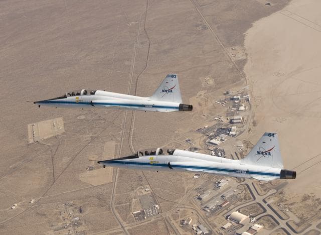 NASA image: NASA Dryden's two T-38A mission support aircraft fly in tight formation while conducting a pitot-static airspeed calibration check near Edwards Air Force Base