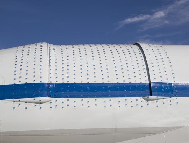 NASA image: Tiny two-inch string tufts blanket the telescope cavity door and related fairings to aid visual monitoring of airflow patterns during SOFIA 747SP flight tests