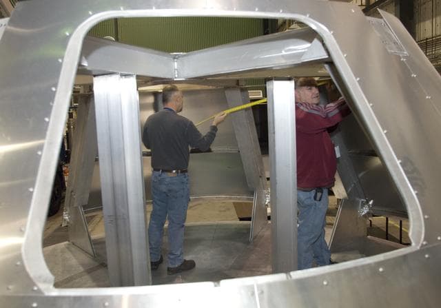 NASA image: NASA Dryden technicians take measurements inside a fit-check mockup for prior to systems installation on a boilerplate Orion launch abort test crew capsule.