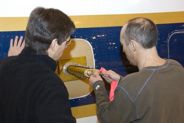Eric Apel and Alan Hills of the National Center for Atmospheric Research install the Trace Organic Gas Analyzer's sensor probe on the exterior of NASA's DC-8