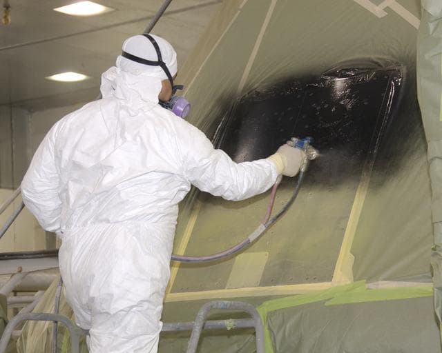 NASA image: A NASA technician paints NASA's first Orion full-scale abort flight test crew module.
