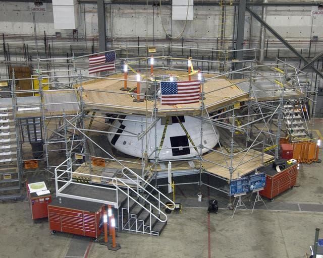 Surrounded by work platforms, the full-scale Orion AFT crew module (center) is undergoing preparations for the first flight test of Orion's launch abort system.