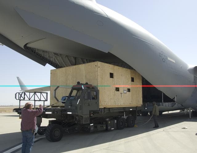 NASA image: A NASA Technician directs loading of the crated SOFIA primary mirror assembly into a C-17 for shipment to NASA Ames Research Center for finish coating