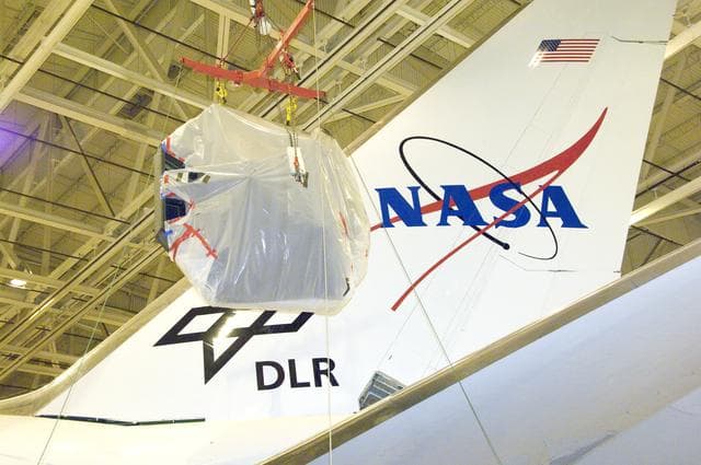 NASA image: SOFIA's primary mirror assembly is lifted above wing level prior to its reinstallation in the telescope cavity of NASA's 747 airborne observatory Oct. 8, 2008