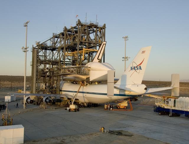 NASA image: Endeavour and its modified 747 carrier aircraft are illuminated by the morning sun after mating was completed in the Mate-DeMate gantry at NASA DFRC