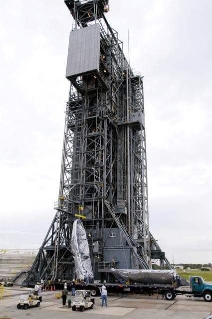 NASA image: KENNEDY SPACE CENTER, FLA. - At Launch Complex 17-A, Cape Canaveral Air Force Station, the first half of the fairing for the Mars Exploration Rover 2 (MER-2/MER-A) is raised to a vertical position for its lift up the launch tower.  The fairing will be installed around the payload for protection during launch.  The MER Mission consists of two identical rovers designed to cover roughly 110 yards each Martian day over various terrain. Each rover will carry five scientific instruments that will allow it to search for evidence of liquid water that may have been present in the planet's past.  Identical to each other, the rovers will land at different regions of Mars.  Launch date for MER-A  is scheduled for June 5.