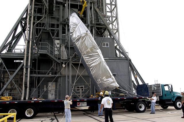 NASA image: KENNEDY SPACE CENTER, FLA. - At Launch Complex 17-A, Cape Canaveral Air Force Station, the second half of the fairing for the Mars Exploration Rover 2 (MER-2/MER-A) is raised to a vertical position for its lift up the launch tower.  The fairing will be installed around the payload for protection during launch.  The MER Mission consists of two identical rovers designed to cover roughly 110 yards each Martian day over various terrain. Each rover will carry five scientific instruments that will allow it to search for evidence of liquid water that may have been present in the planet's past.  Identical to each other, the rovers will land at different regions of Mars.  Launch date for MER-A  is scheduled for June 5.