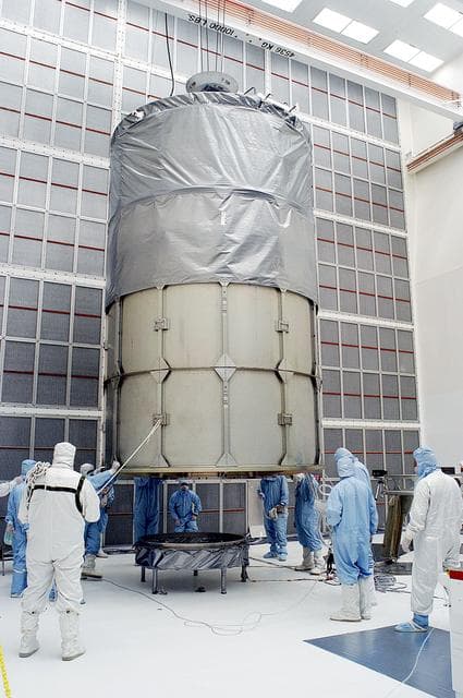 NASA image: KENNEDY SPACE CENTER, FLA. -  Workers in NASA Spacecraft Hangar AE prepare to remove the canister from around the Space Infrared Telescope Facility (SIRTF), which has been returned to the hangar from the launch pad.   SIRTF will remain in the clean room until it returns to the pad in early August. One of NASA's largest infrared telescopes to be launched, SIRTF will obtain images and spectra by detecting the infrared energy, or heat, radiated by objects in space.