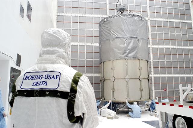 NASA image: KENNEDY SPACE CENTER, FLA. -  Workers in NASA Spacecraft Hangar AE prepare to remove the canister from around the Space Infrared Telescope Facility (SIRTF), which has been returned to the hangar from the launch pad.   SIRTF will remain in the clean room until it returns to the pad in early August. One of NASA's largest infrared telescopes to be launched, SIRTF will obtain images and spectra by detecting the infrared energy, or heat, radiated by objects in space.
