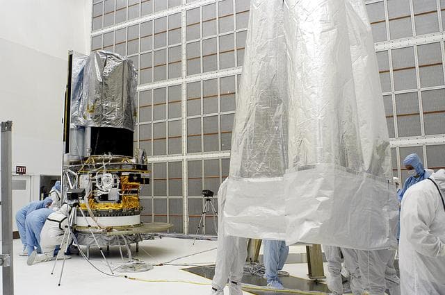 NASA image: KENNEDY SPACE CENTER, FLA. -  Workers in NASA Spacecraft Hangar AE remove the protective cover from around the Space Infrared Telescope Facility (SIRTF), which has been returned to the hangar from the launch pad.   SIRTF will remain in the clean room until it returns to the pad in early August. One of NASA's largest infrared telescopes to be launched, SIRTF will obtain images and spectra by detecting the infrared energy, or heat, radiated by objects in space.