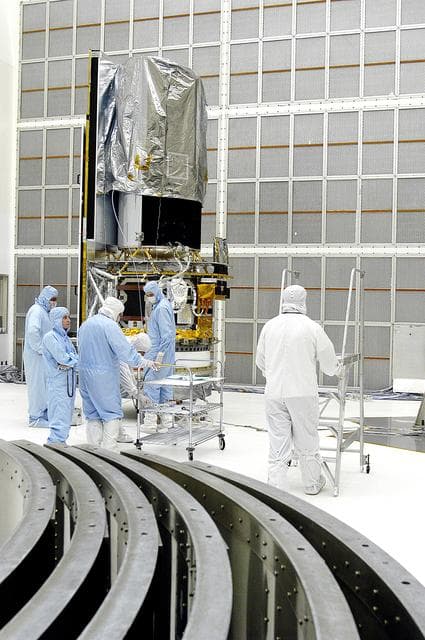 NASA image: KENNEDY SPACE CENTER, FLA. -  Workers in NASA Spacecraft Hangar AE prepare to begin further processing of the Space Infrared Telescope Facility (SIRTF), which has been returned to the hangar from the launch pad. Sections of the transportation canister used in the move are in the foreground.  SIRTF will remain in the clean room until it returns to the pad in early August. One of NASA's largest infrared telescopes to be launched, SIRTF will obtain images and spectra by detecting the infrared energy, or heat, radiated by objects in space.