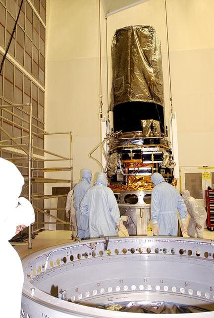 NASA image: KENNEDY SPACE CENTER, FLA. -  Workers in NASA Spacecraft Hangar AE check the placement of the Space Infrared Telescope Facility (SIRTF), which has been returned to the hangar from the launch pad for further processing. SIRTF will remain in the clean room until it returns to the pad in early August. One of NASA's largest infrared telescopes to be launched, SIRTF will obtain images and spectra by detecting the infrared energy, or heat, radiated by objects in space.