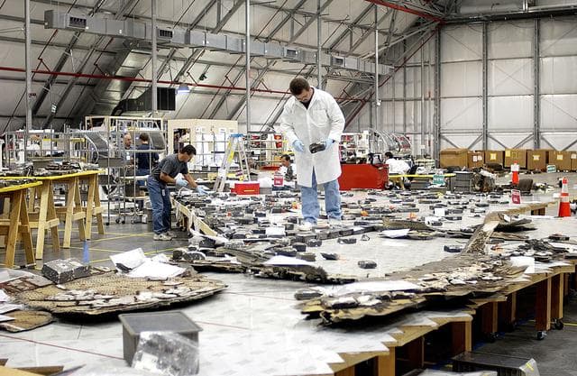 NASA image: KENNEDY SPACE CENTER, FLA. -  Members of the Columbia Reconstruction Project Team place pieces of debris on a table in the RLV Hangar.   The items shipped to KSC number more than 82,000 and weigh 84,800 pounds or 38 percent of the total dry weight of Columbia.  Of those items, 78,760 have been identified, with 753 placed on the left wing grid in the Hangar.